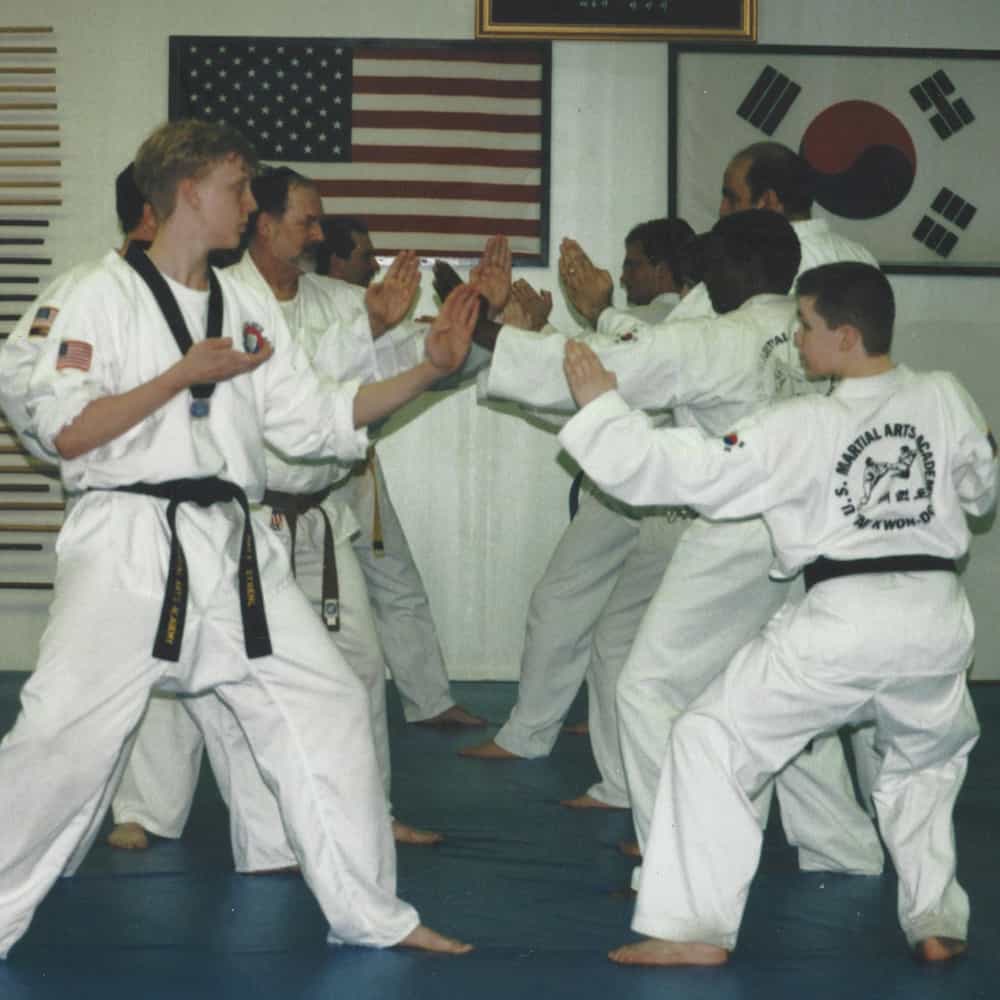 Student bowing to show respect while receiving new belt in kids class